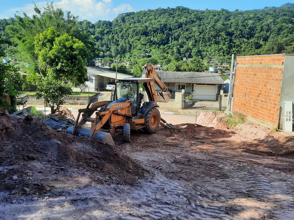 Retroescavadeira nivelando lote residencial